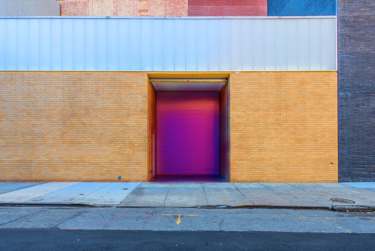 Violettes Eingangstor in einer Industriebackstein-Fassade